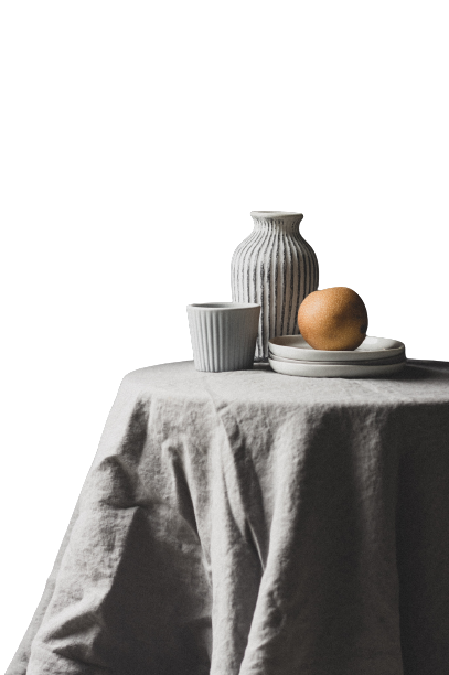 Ceramic objects and an orange on a table