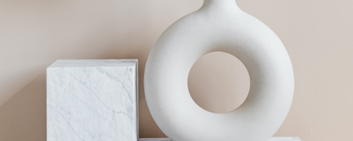 White, round, ceramic vase holding dried wheat